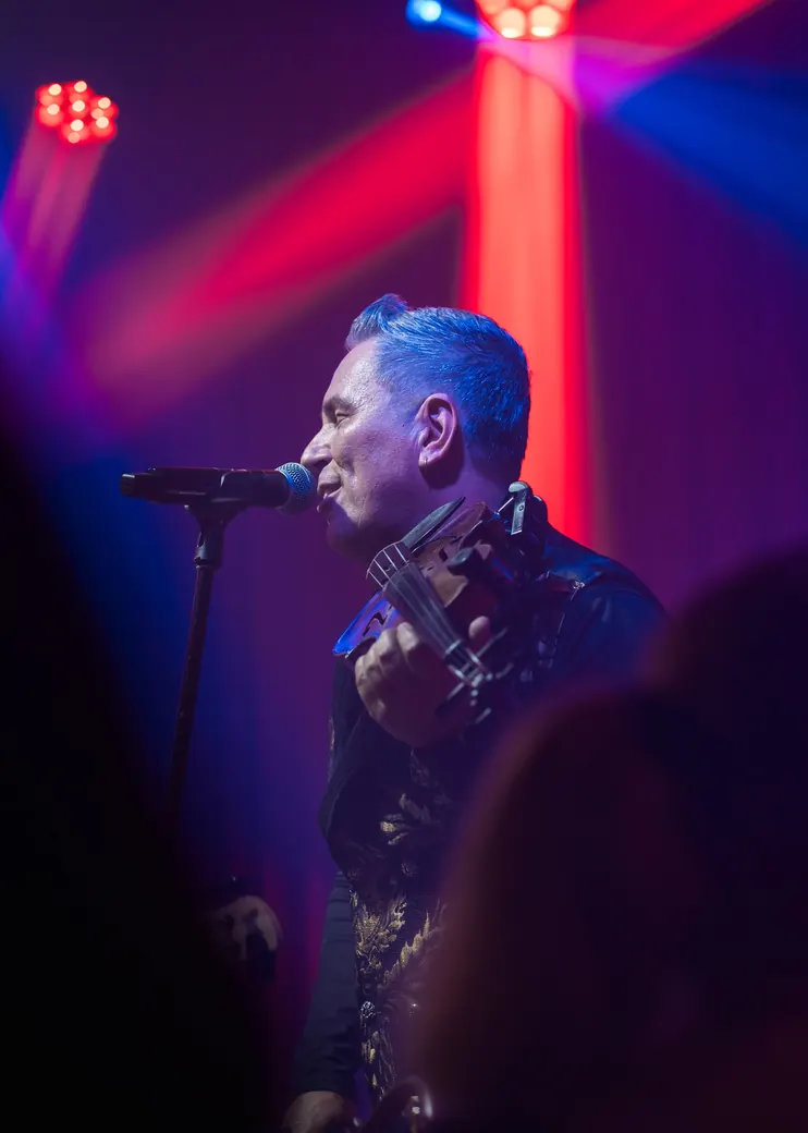 Abraham singing with his violin on stage